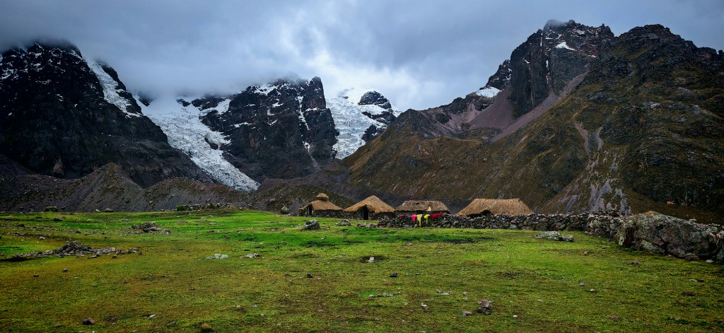 Turquoise glacial lake reflecting snow-capped peaks on the Huayhuash Circuit, Peru