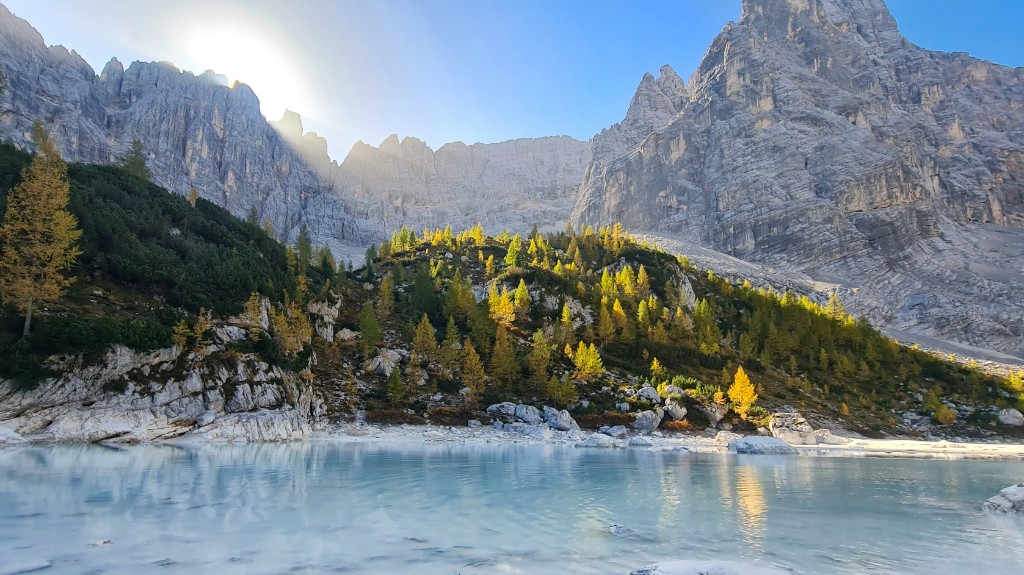 Milky turquoise water of Lago di Sorapis surrounded by pale Dolomite peaks, Italy