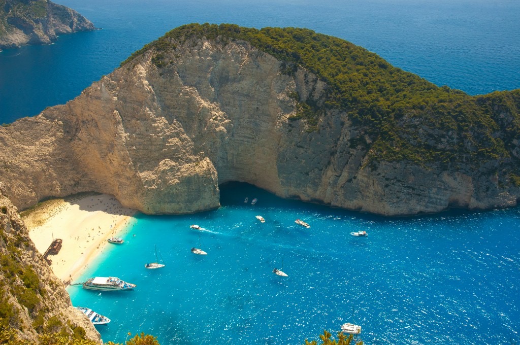Aerial view of Navagio Beach cove with turquoise water and boats, Zakynthos Greece