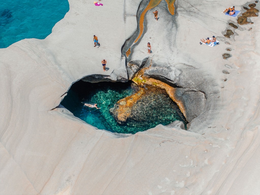 White volcanic rock formations at Sarakiniko beach, Milos, Greece, overlooking turquoise water